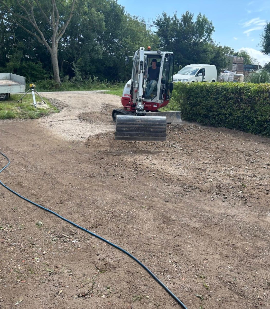 Pieter in de cabine van de graafmachine terwijl hij de grond glad strijkt